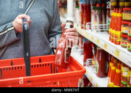 L'emballage de ketchup dans les mains et un panier Banque D'Images