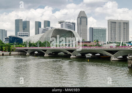 Un bateau de croisière connu comme twakows à travers la célèbre rivière Singapour. Le bâtiment à l'arrière est le fameux théâtre sur la baie, l'Esplanade. Banque D'Images