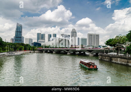 Un bateau de croisière et connu comme le twakows à travers la célèbre rivière Singapour. Le bâtiment à l'arrière est le fameux théâtre sur la baie, l'Esplanade. Banque D'Images