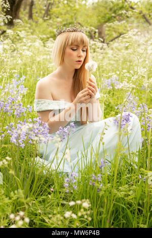 Femme au printemps meadow soufflé fleurs de pissenlit Banque D'Images