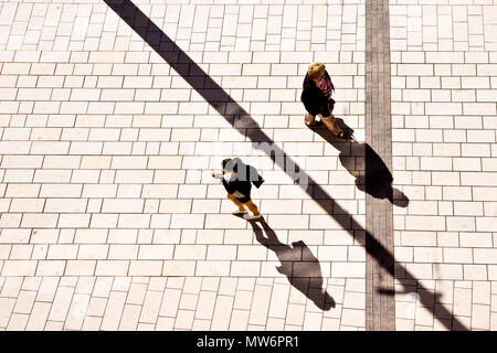 Deux femmes marchant dans la rue en une journée ensoleillée, l'ombre projetée sur le trottoir, vue de dessus Banque D'Images