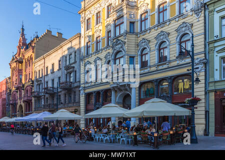 Les personnes bénéficiant d'un repas du soir de boire dans un café bar restaurant dans la rue Piotrkowska, Lodz, Pologne Banque D'Images