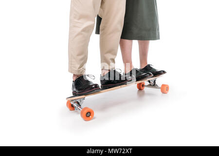 La section basse de casual couple riding on skateboard isolated on white Banque D'Images