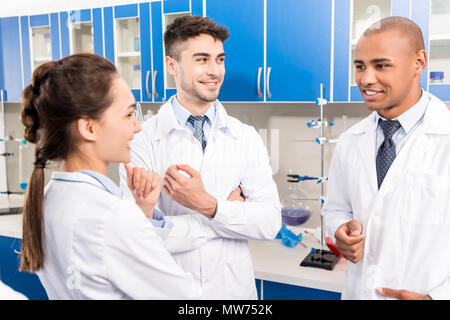 Groupe des travailleurs médicaux dans des blouses de laboratoire, discuter de travail en laboratoire Banque D'Images