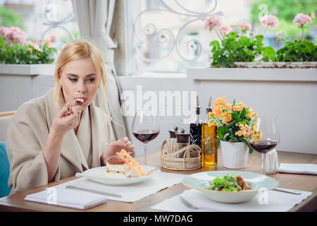 Femme blonde dans un restaurant en compagnie de ses glaces gâteau désert Banque D'Images