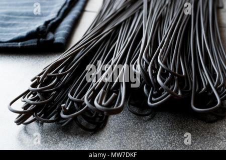 Les pâtes Spaghetti noir aromatisé avec de l'encre de calmar ou seiche. L'alimentation biologique. Banque D'Images