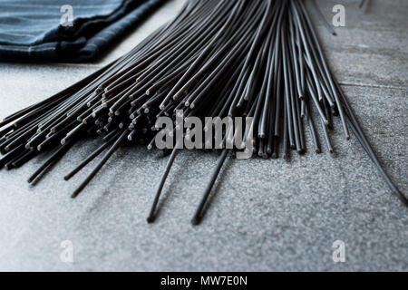 Les pâtes Spaghetti noir aromatisé avec de l'encre de calmar ou seiche. L'alimentation biologique. Banque D'Images