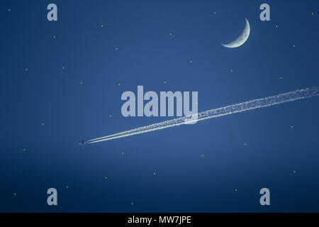 Jet Plane flying passé demi lune on blue sky Banque D'Images