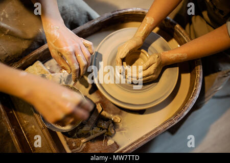 Potter Maître enseigne l'enfant de travailler sur le tour de potier. Close up shot Banque D'Images