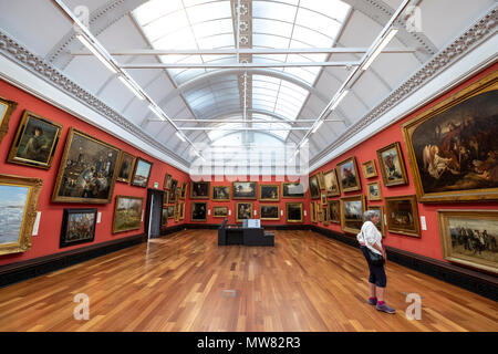 Femme à la recherche de peintures à l'intérieur de la galerie Victoria McManus art gallery and museum à Dundee, Écosse, Royaume-Uni, Tayside Banque D'Images