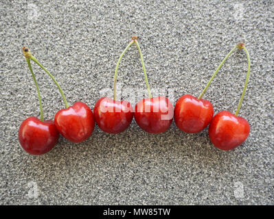 Cerises rouges frais sur une pierre grisâtre. Les aliments biologiques ou fond d'arrière-plan Banque D'Images