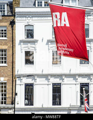 Le soleil brille sur le drapeau de la Royal Academy of Arts alors qu'il se trouve devant le bâtiment de Savile Row, dans le centre de Londres Banque D'Images