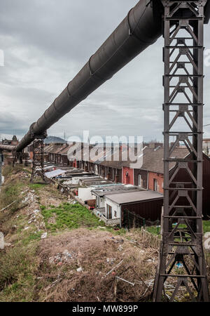 Maisons de la rue dominé par les tuyaux d'alimentation de gaz industriels dans la Rue du Châtelet à Charleroi, Belgique Banque D'Images