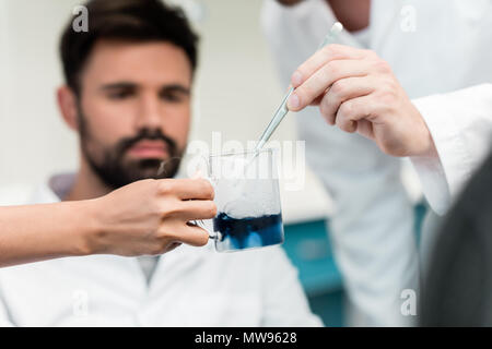 Vue rapprochée de scientifiques faisant expérimenter avec pipette et réactif Banque D'Images