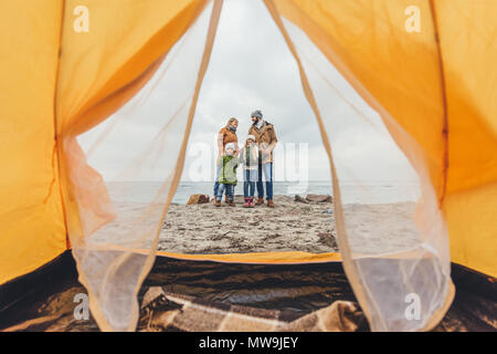 Happy young family standing ensemble sur le littoral et dans l'embrassant Banque D'Images