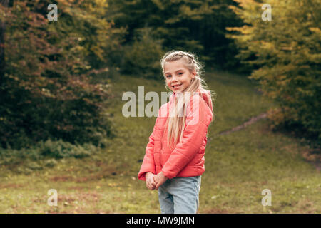 Portrait de l'adorable petit enfant smiling at camera in autumn park Banque D'Images