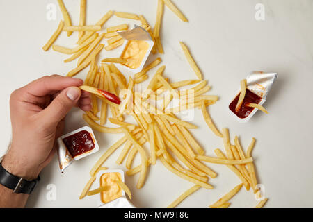 Cropped shot of man taking frites de surface blanche Banque D'Images