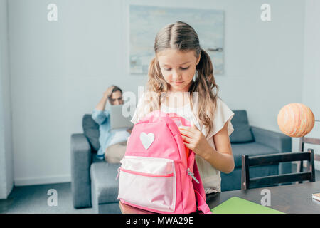 Cute little girl préparation sac à dos pour l'école Banque D'Images