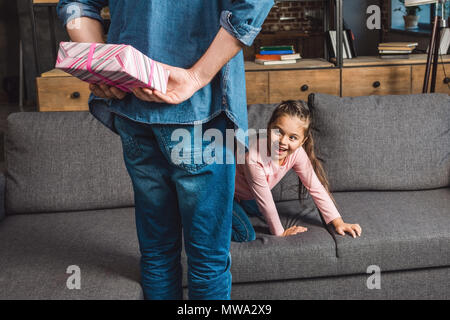 Père Don pour se cacher derrière l'arrière petite fille excité Banque D'Images