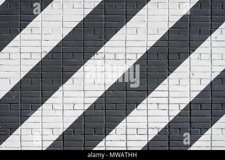 Surface de briques peintes en diagonale mur en noir et blanc, comme les graffitis. Texture grunge graphique de mur. Résumé Contexte moderne Banque D'Images