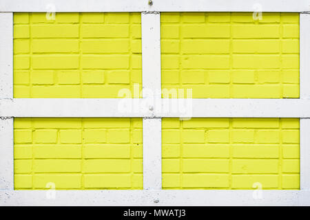 La texture du mur de briques peintes en jaune, blanc, châssis métallique quadrangulaire en fond urbain, l'espace pour le texte. Lumière abstraite toile, motif, papier peint, design de bannières, placez le texte Banque D'Images