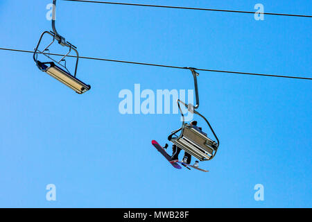 Téléski avec sièges allant sur la montagne et les chemins des cieux et snowboards Banque D'Images