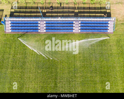 Terrain de football avec des têtes d'arrosage et vide fans sièges. Vue de dessus Banque D'Images