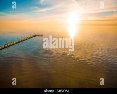 Peu de paysage de coucher de soleil sur l'eau calme et jetée en bois Banque D'Images