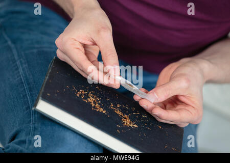 Mains d'une personne de rouler un cigare Banque D'Images