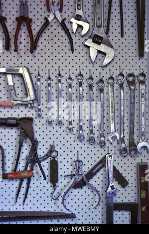 Outils à main et clés disposés verticalement et regroupés pour faciliter l'accès sur un panneau perforé Banque D'Images