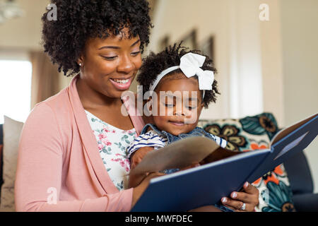 Mère lire un livre à sa petite fille. Banque D'Images