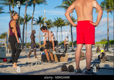 MIAMI - 29 décembre 2017 : les jeunes hommes musclés s'entraîner dans la salle de sport en plein air appelé Muscle Beach dans le parc Lummus. Banque D'Images