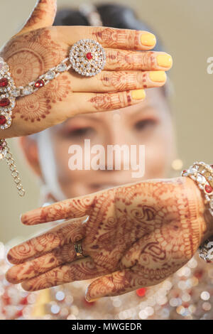 Indiens et Pakistanais mariée de style mariage montrant d'oreille, bracelets et belle conception Mehndi Banque D'Images