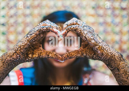 Indiens et Pakistanais de mariage mariée de prendre une forme de coeur sa main et beau design style Mehndi Banque D'Images