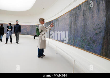 Une touriste photographie d'une peinture de Monet Nymphéas Nymphéas au Musée de l'Orangerie Jardin des Tuileries à Paris France KATHY DEWITT Banque D'Images