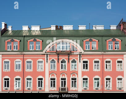 Façade d'un vieux bâtiment avec un toit mansardé. Fenêtres et murs roses Banque D'Images