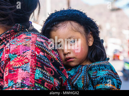 Panajachel, Guatemala - Avril, 25, 2018 : vue extérieure de la femme indienne non identifiés avec bébé à l'arrière s'occupe du marché local dans le lac Atitlan, Guatemala Banque D'Images