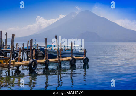 Panajachel, Guatemala - Avril, 25, 2018 : Bateaux à Piers dans le village de San Pedro, lac Atitlan dans l'arrière-plan lors d'une superbe journée Banque D'Images