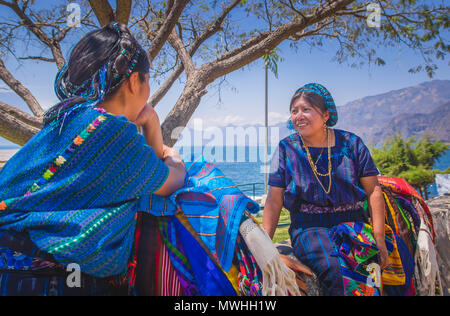 Panajachel, Guatemala - Avril, 25, 2018 : vue extérieure de la femme indigène non identifiée,portant des vêtements typiques de parler chaque otherin avant du Lac Atitlan et le volcan en arrière-plan au Guatemala Banque D'Images