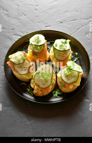 Toast sandwiches avec du saumon, des œufs brouillés et des tranches de concombres Banque D'Images