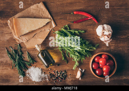 Vue de dessus le parmesan, l'huile et ingrédients frais sur table en bois Banque D'Images