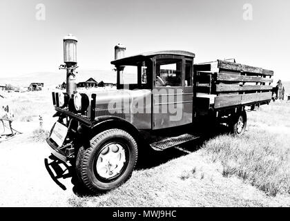 Image en noir et blanc du camion Ford graham en bois encadré 1927 abandonné dans la ville fantôme de Bodie, avec maisons délictées, comté mono, Californie Banque D'Images