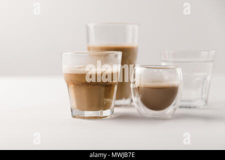 Lunettes avec du café et du lait sur fond blanc Banque D'Images