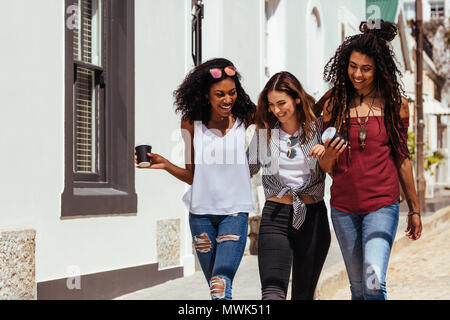 Trois femmes portant des vêtements à la mode marche sur street holding coffee lunettes. Banque D'Images