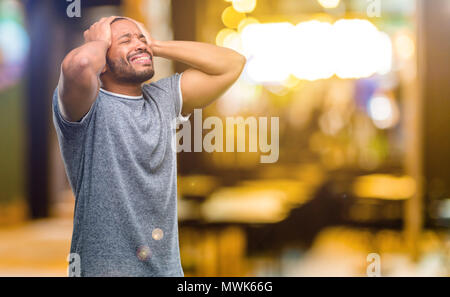 African American man with beard stressant laissant les mains sur la tête, terrifié, en panique, des cris dans la nuit Banque D'Images