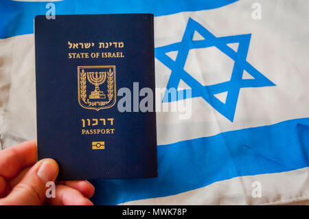 Main tenant le passeport de l'état d'Israël, drapeau israélien sur l'arrière-plan. La citoyenneté israélienne, Israël concept "d'illustration de passeport des arkon Banque D'Images