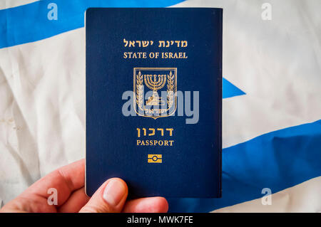 Main tenant le passeport de l'état d'Israël, drapeau israélien sur l'arrière-plan. La citoyenneté israélienne, Israël concept "d'illustration de passeport des arkon Banque D'Images