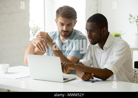 Collègues discuter affaires questions, working at laptop Banque D'Images