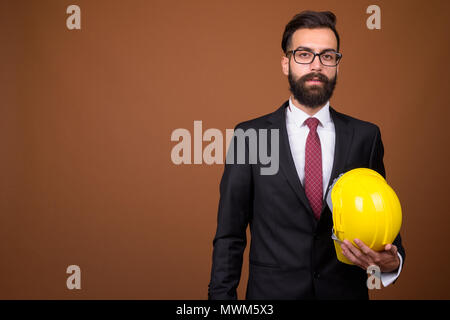 Beau jeune homme persan barbu contre brown background Banque D'Images
