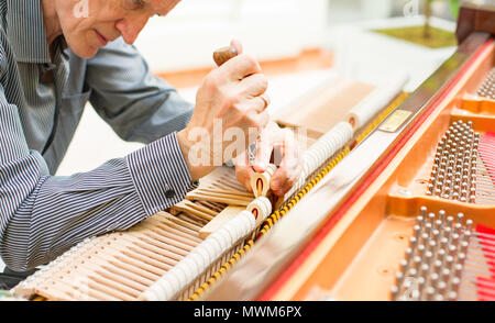 Personnes âgées technicien piano mécanisme de réparation. Banque D'Images